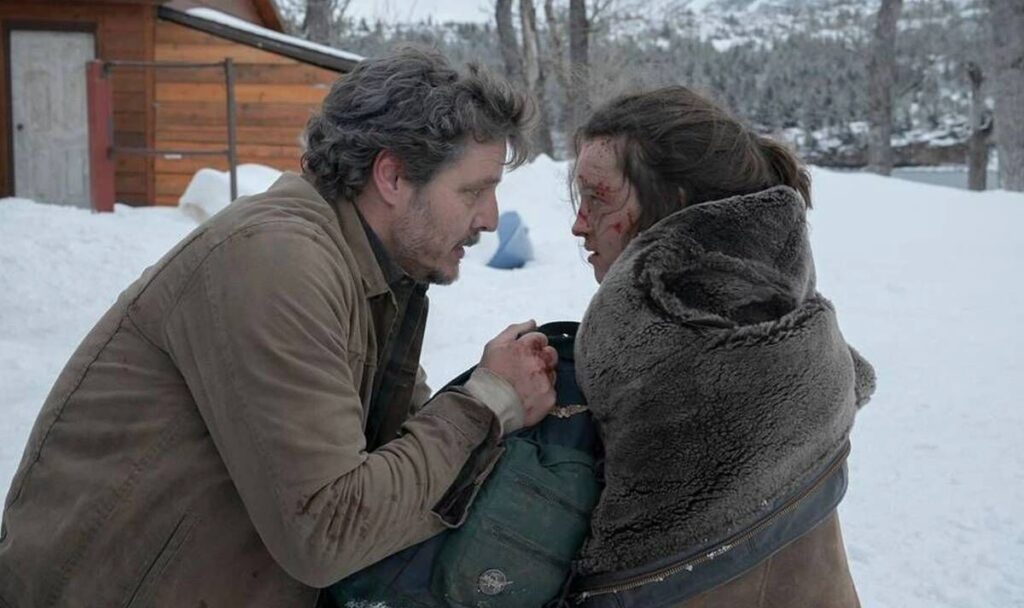 Joel comforts a bloodied Ellie in the snow after her traumatic escape, deepening their bond in The Last of Us Episode 9.