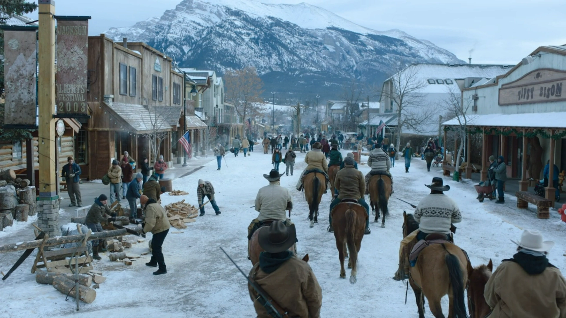 Scene from The Last of Us: Joel and Ellie arrive in snowy Jackson, a peaceful frontier town surrounded by mountains and guarded by riders.