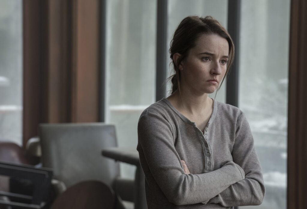 Kaitlyn Dever as Abby stands tense and emotional in The Last of Us Season 2, embodying the antihero's internal conflict.