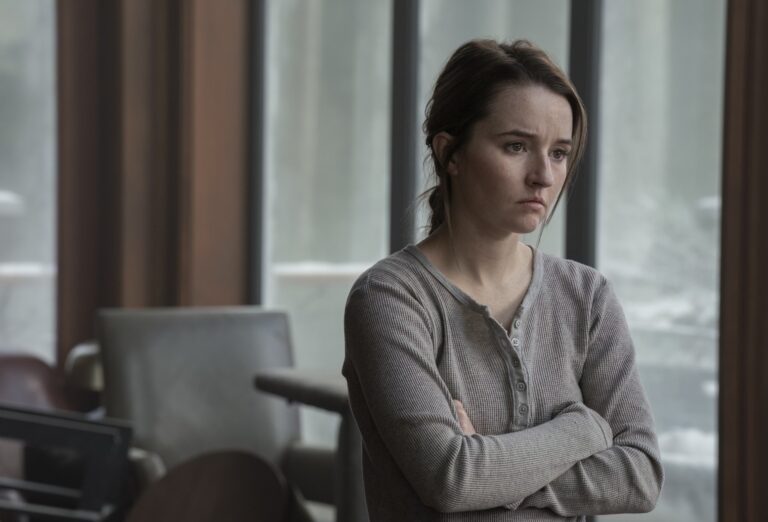 Kaitlyn Dever as Abby stands tense and emotional in The Last of Us Season 2, embodying the antihero's internal conflict.